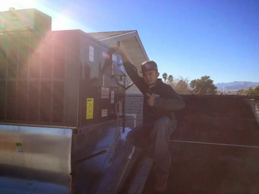HVAC technician performing Heat Pump Repair on a rooftop unit in Clarcona